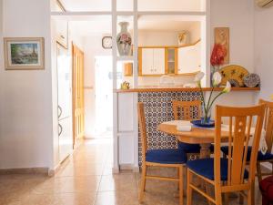 cocina y comedor con mesa y sillas en Casa Trudy, en Torrevieja