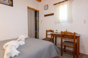 a bedroom with a bed and a desk with towels at Green Bay Studio 1 in Sifnos