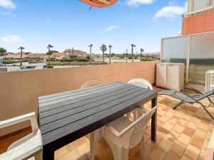 Una mesa y sillas de madera en un balcón. en Studio cosy 4 pers à 150m de la plage !, en Le Barcarès