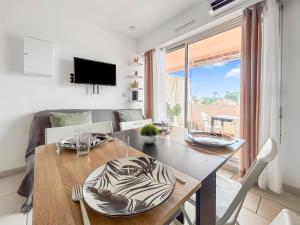 Un comedor con una mesa y un sofá. en Studio cosy 4 pers à 150m de la plage !, en Le Barcarès