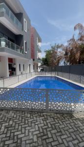 a swimming pool in front of a building at Cozy 2BDR Apt In Lekki With Free WiFi & Swimming Pool in Ibeju