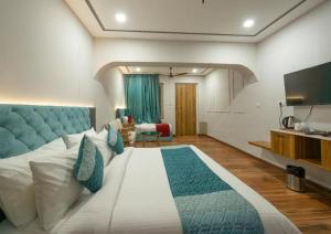 a bedroom with a large bed with a blue headboard at Excel Hotels & Resorts Mall Road Nainital in Nainital