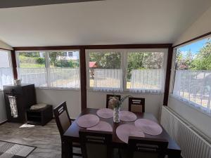 una sala da pranzo con tavolo, sedie e finestre di Holdviola 2 Apartman a Miskolc