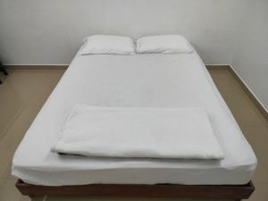 a white bed with two pillows on top of it at Travellers Space 2 in Kuantan +16 photos