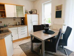 a kitchen with a table and chairs in a kitchen at Residenz Strandkrone 02 in Kühlungsborn
