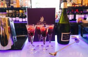 a group of wine glasses on a counter with a bottle of wine at Boutique By Browns in Worcester