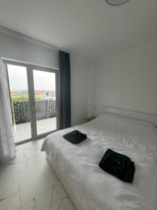 a bedroom with a bed with two black bags on it at City Vibe Apartment in Baia Mare
