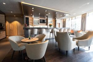 a restaurant with white chairs and a bar at Hotel Panorama Hamburg-Harburg in Hamburg