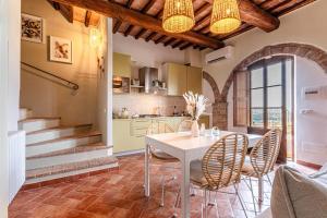 une cuisine et une salle à manger avec une table et des chaises dans l'établissement Nel cuore della Toscana con piscina, à Asciano