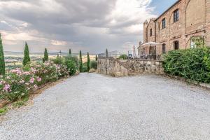 une allée en pierre devant un bâtiment dans l'établissement Nel cuore della Toscana con piscina, à Asciano