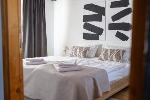 a bedroom with a bed with two towels on it at Hilltop House. in Erdut