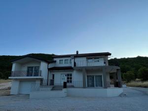 a large white house with balconies on top of it at Villa Imvelo Lovrec - Spacious Villa With Private Pool in Lovreć