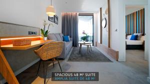 a living room with a couch and a table in a room at HOVIMA Suites Costa Adeje in Adeje