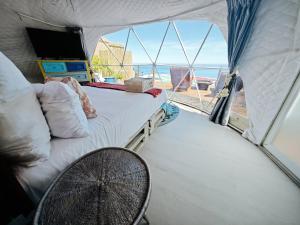 Una habitación con una cama y una mesa en una tienda de campaña. en Seascape Camps Bay, en Ciudad del Cabo