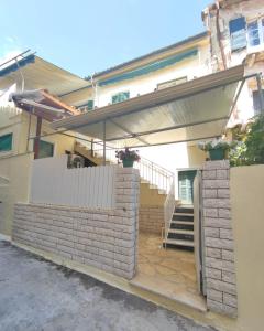 a house with a brick wall and a fence at Anna's Apartment in Gaios