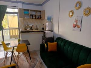 Una sala de estar con un sofá verde y una mesa. en Bamburi luxury studios, en Mombasa 3 fotos más