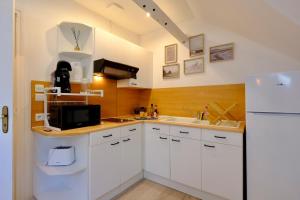 a kitchen with white cabinets and a white refrigerator at Verneuil sur Avre - Romantic room in Verneuil d’Avre et d’Iton +12 photos