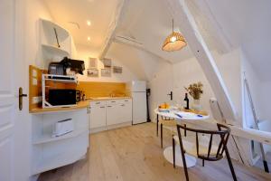 a kitchen with a table and a kitchen with white cabinets at Verneuil sur Avre - Romantic room in Verneuil d’Avre et d’Iton
