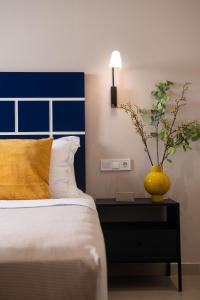 a bedroom with a bed with a yellow vase on a table at Living Yard Thissio in Athens
