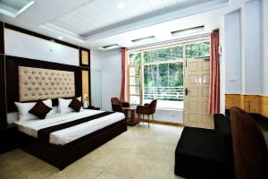 a bedroom with a bed and a table and a window at Decent Stays in Shimla