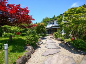秋田市にあるみんなの実家門脇家の岩と木と家のある庭