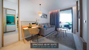 a living room with a couch and a dining room at HOVIMA Suites Costa Adeje in Adeje