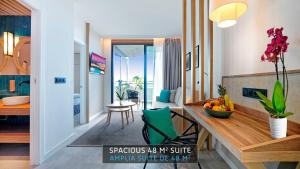 a kitchen and living room with a table with a bowl of fruit at HOVIMA Suites Costa Adeje in Adeje