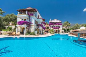 a villa with a swimming pool in a resort at Hadrian Hotel in Kaş