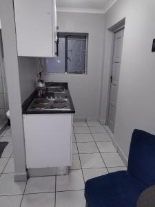 una cocina con estufa y encimera en Grace Villas 5, en East London