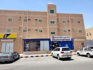 two cars parked in a parking lot in front of a building at العييري للشقق المخدومة النعيرية 1 in Al Nairyah