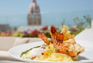 a plate of food with shrimp and pasta on a table at Movich Hotel Cartagena de Indias in Cartagena de Indias