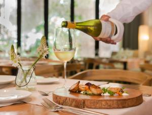a person pouring a glass of wine on a table at Movich Hotel Cartagena de Indias in Cartagena de Indias