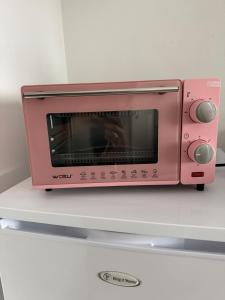 a pink toaster oven sitting on top of a counter at Charming little Bagatelle studio in Talence