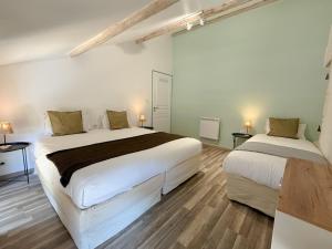 two beds in a room with white walls and wooden floors at Les gîtes du pied mulet in La-Gripperie-Saint-Symphorien +54 photos