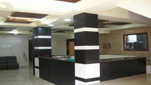a lobby with a black and white striped pillar at Hotel Woodside in Tirupati