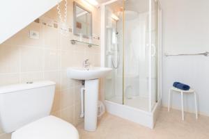 een badkamer met een douche, een toilet en een wastafel bij Le Canada in Hermanville-sur-Mer