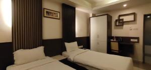 a hotel room with two beds and a mirror at Hotel Shiny Villa in Rānchī