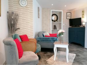 a living room with two couches and a tv at Le Relais de Mont in Faye-dʼAnjou