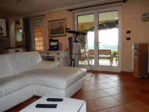 a living room with a white couch and a camera at Villa Claudia in Quiliano