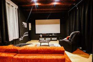 ein Wohnzimmer mit Sofa und Fernseher in der Unterkunft Cinéma privé - Movie Night Loft in La Force + 6 Fotos