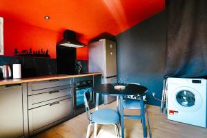 eine Küche mit einem Tisch und einer Waschmaschine in der Unterkunft Cinéma privé - Movie Night Loft in La Force