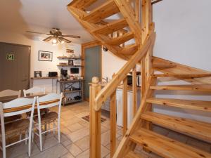 a kitchen and dining room with a wooden spiral staircase at SKOLO Apartment in Selfoss