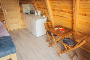 a small room with a table and a kitchen in a cabin at Camp Nomad Sutjeska in Tjentište