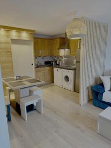 Una cocina y una sala de estar con una mesa y un sofá. en Les Duc(s) de l'Airelle, en Les Carroz d'Araches