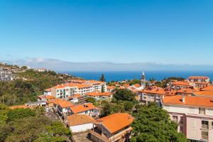 a view of a town with orange roofs and the ocean at GuestReady - Caniço city view in Caniço