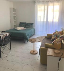 a living room with a couch and a table at Grand Studio calme centre-ville in La Ferté-sous-Jouarre