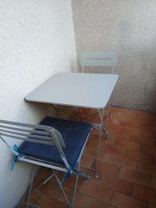 a white desk and a blue chair under a table at Grand Studio calme centre-ville in La Ferté-sous-Jouarre