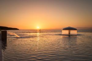 a boat in the water with the sunset in the background at Grand Hotel View in Postira
