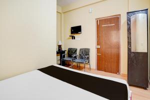 a bedroom with a bed and a desk and a chair at Hotel O PALMS INN ELEGANT STAY in Bengaluru