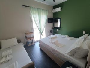 a bedroom with two beds and a green wall at Pool me up 22 apartment in Megali Ammos +27 photos